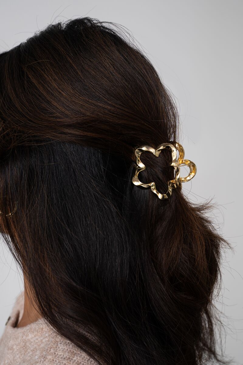 Goudkleurige bloem haarclip gedraaid